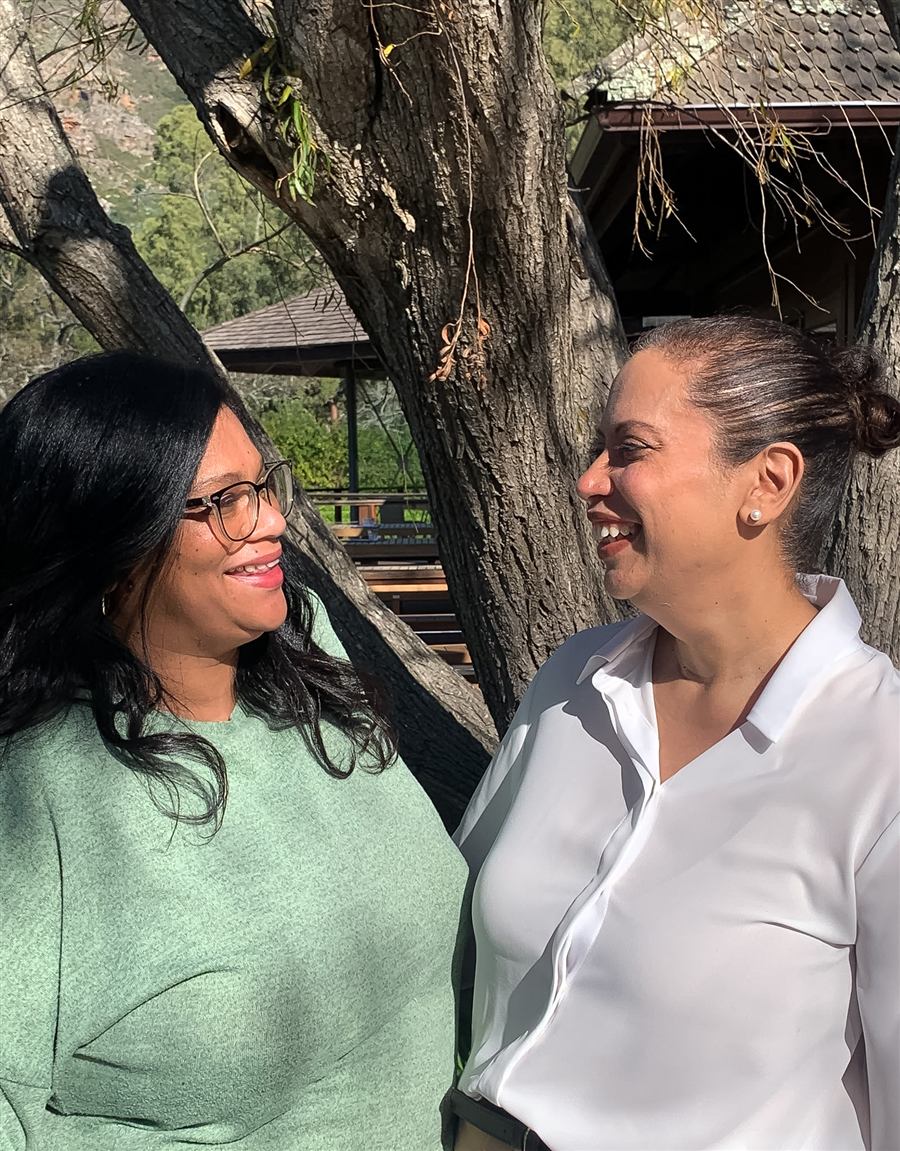 Leanie and Etherecia laughing together under a tree